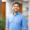 Austin Carter standing in a modern office hallway with a blurred background.