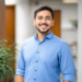 Austin Carter standing in a modern office hallway with a blurred background.