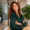 Emily Carter smiling with folded arms in a modern office.